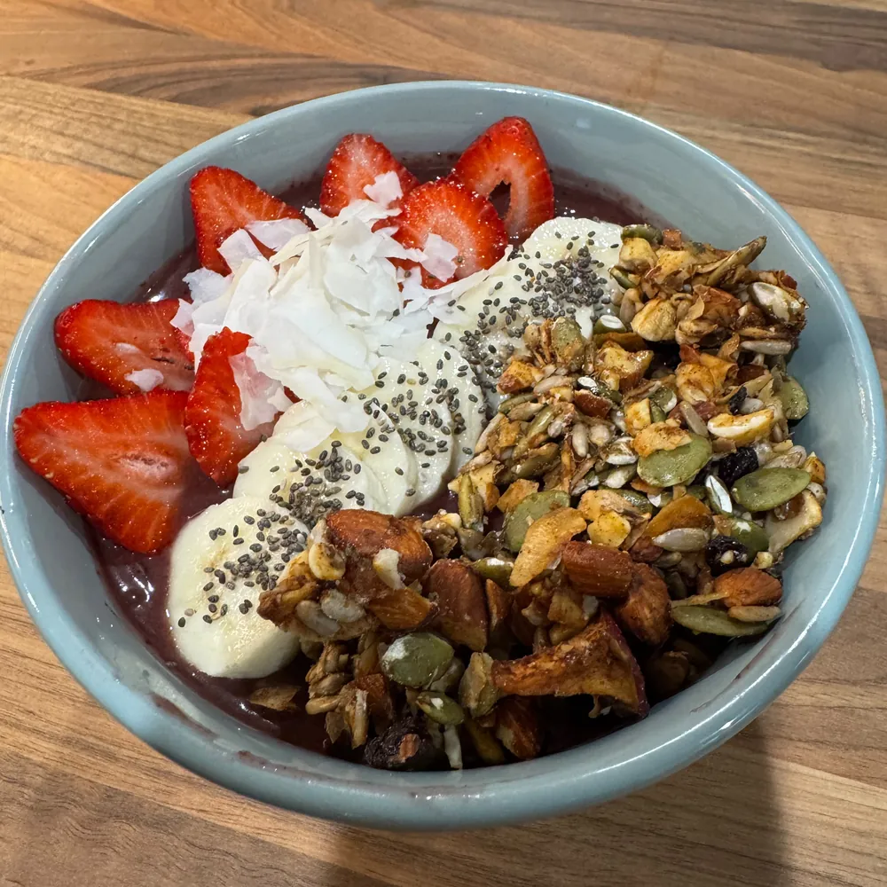 Açaí bowl topped with strawberries, banana, coconut flakes, chia and granola