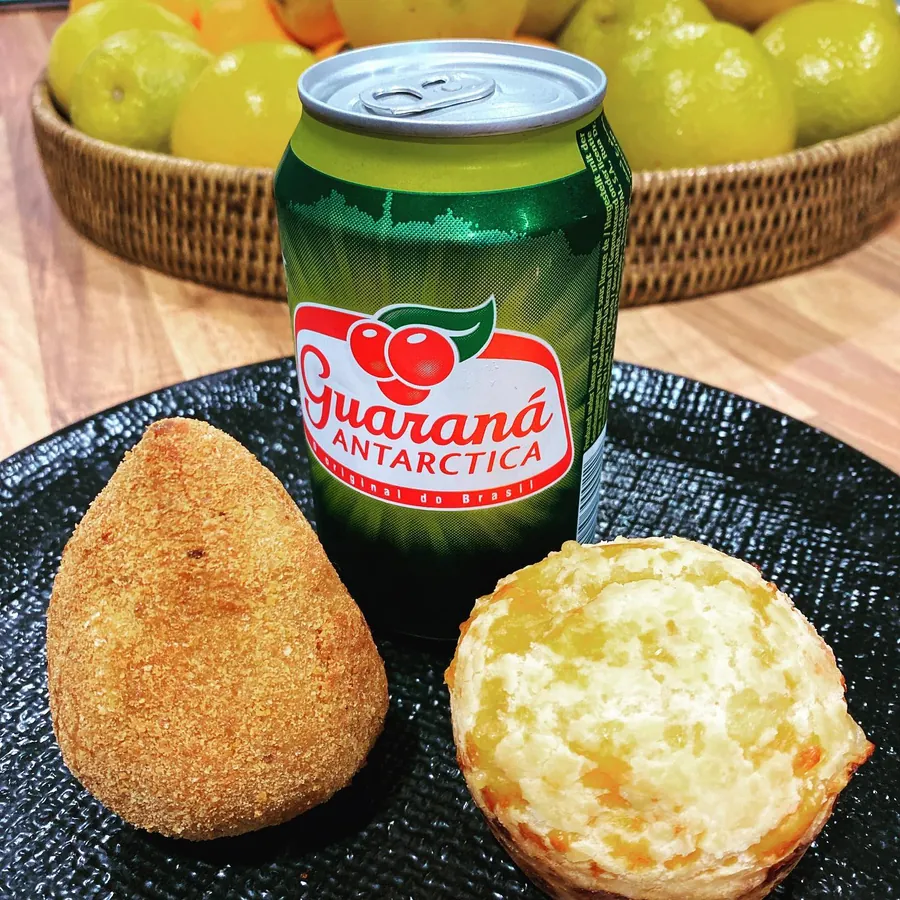 A coxinha and a cheese bread next to a can of Guaraná Antarctica