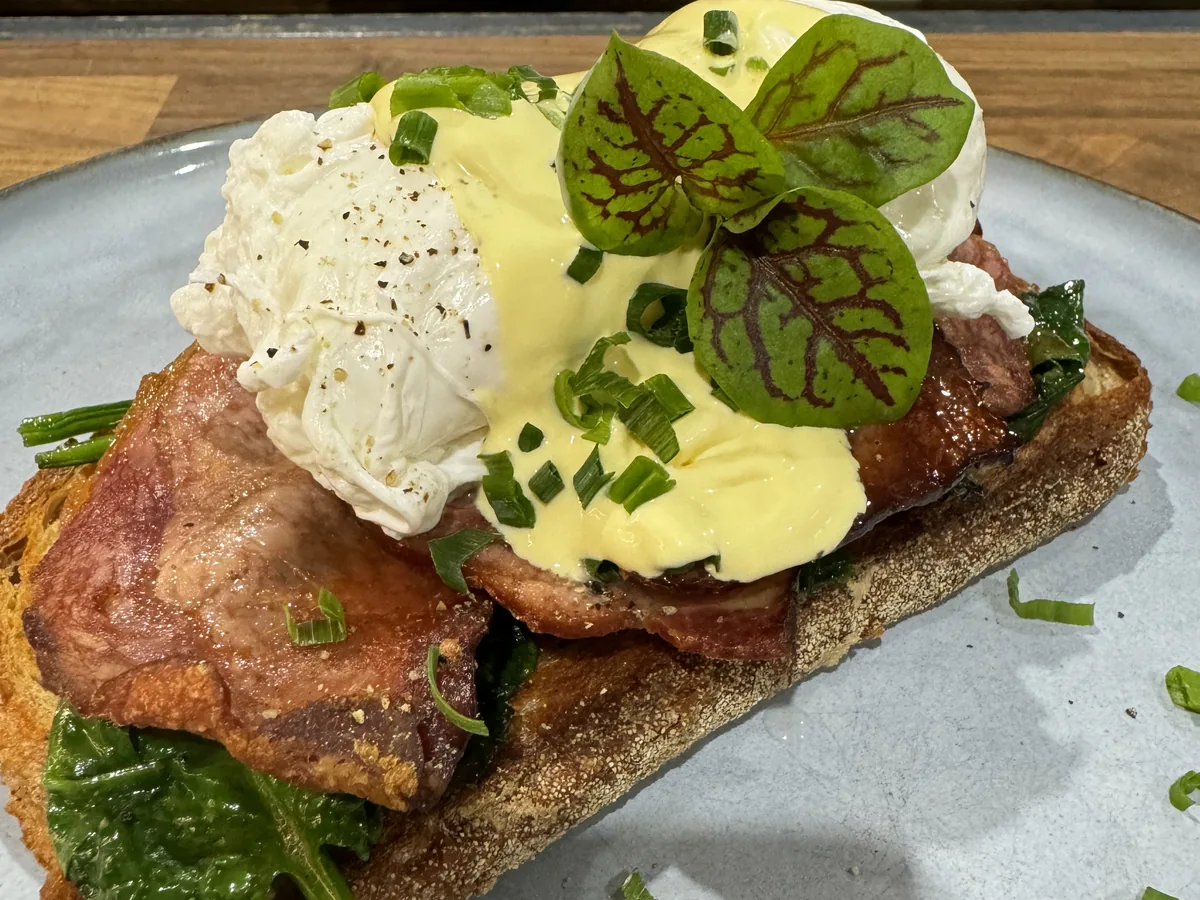 Eggs benedict with bacon, spinach and hollandaise on sourdough