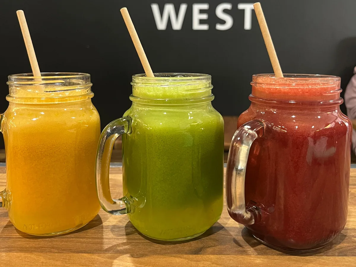 Three fresh juices in jars in front of the Silo West sign