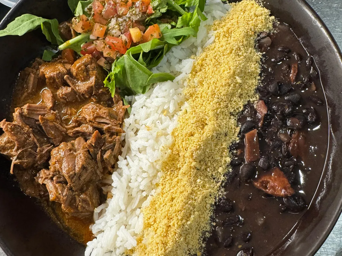Prato Feito with beef stew, rice, cassava flour and black beans