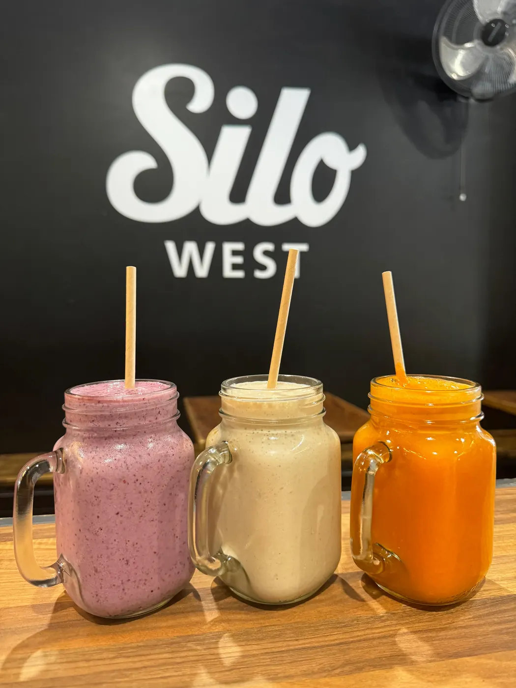 Three smoothies on the bench under the Silo West sign